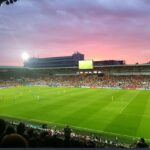 a football pitch at dusk, with the sunset in the background