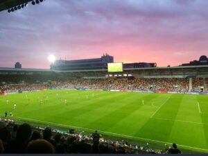 a football pitch at dusk, with the sunset in the background